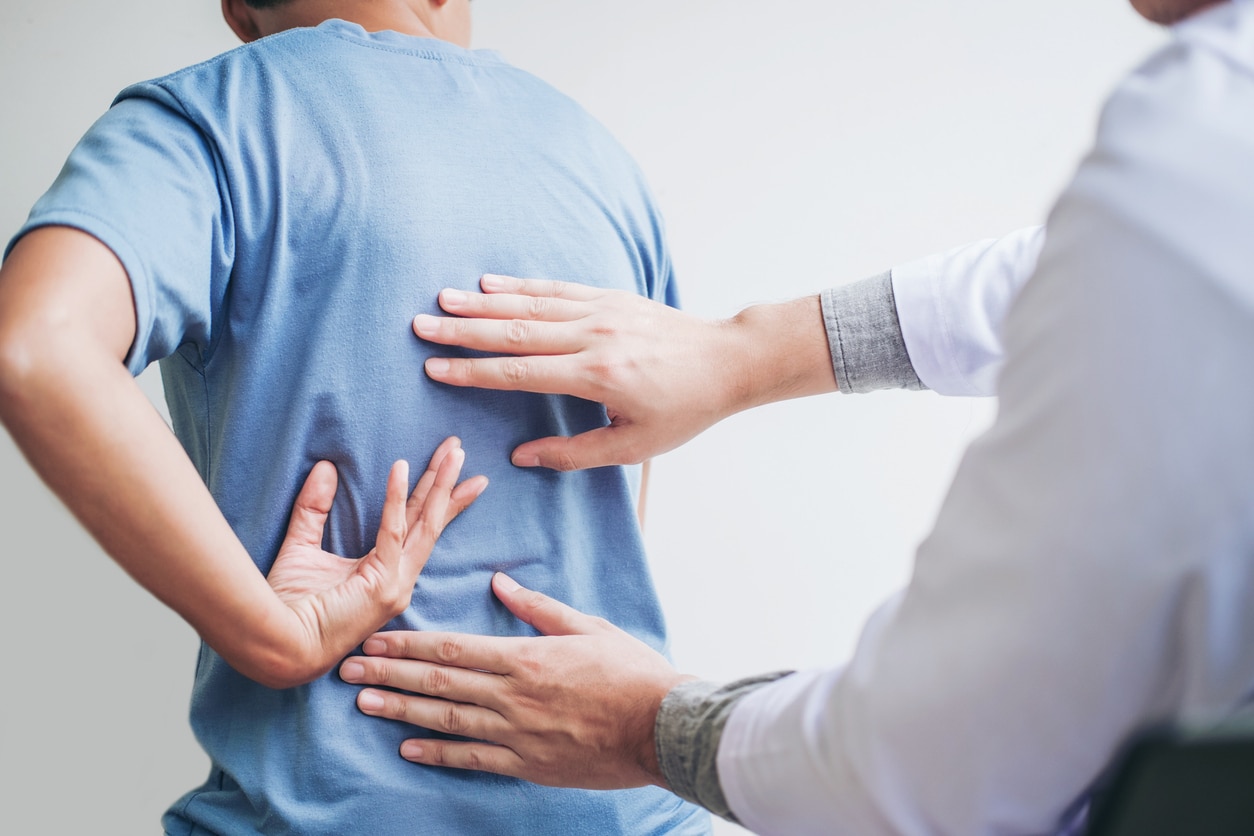 Doctor evaluates patient for back pain