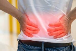 Man’s hands on back, highlighted by red