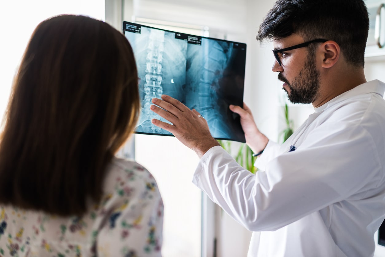 Doctor shows explains MRI image of spine to patient