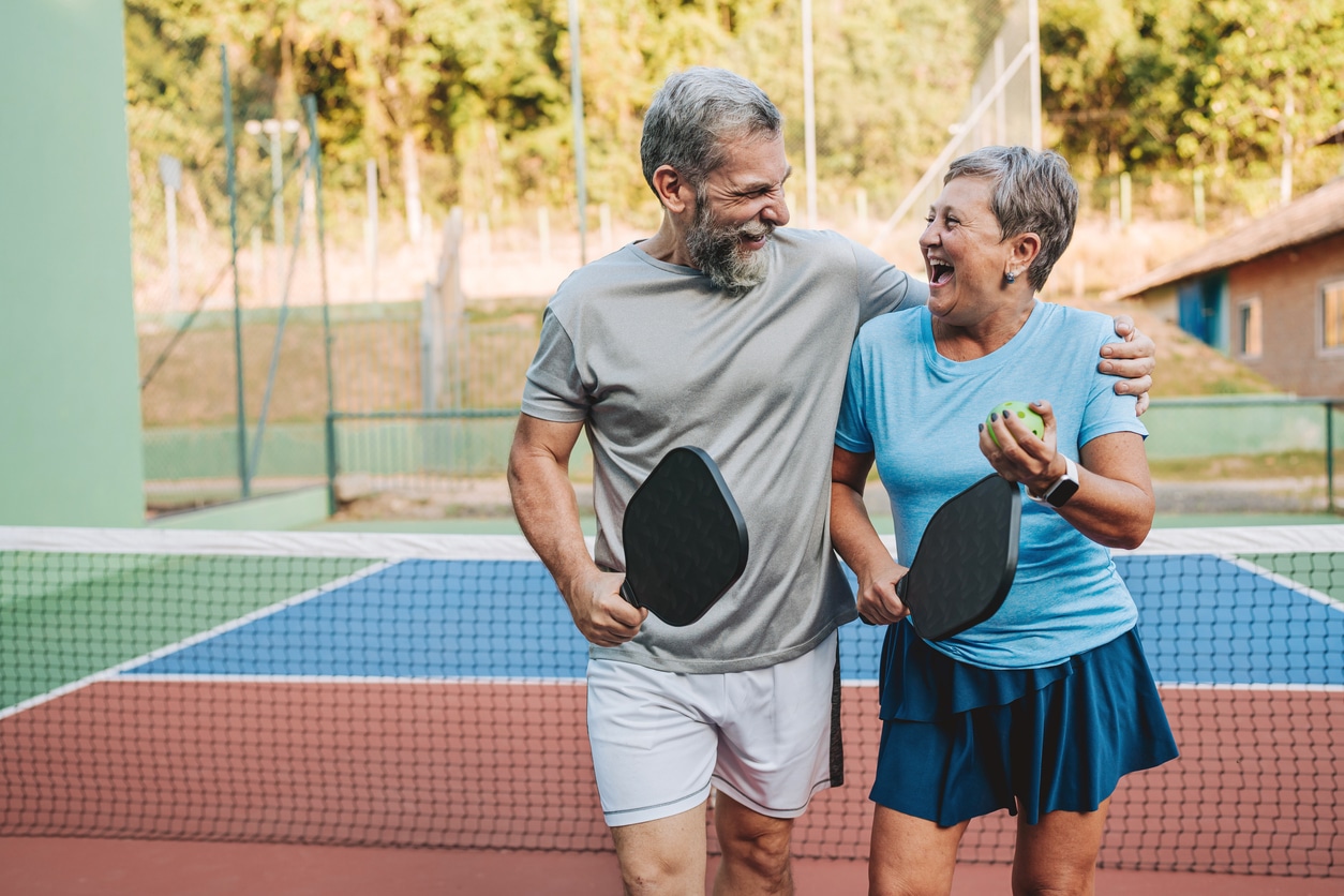 Cheerful senior couple playing pickleball