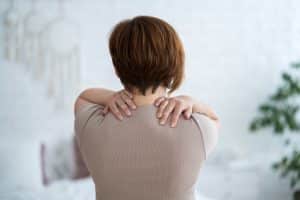 Close-up image of person experiencing upper back pain
