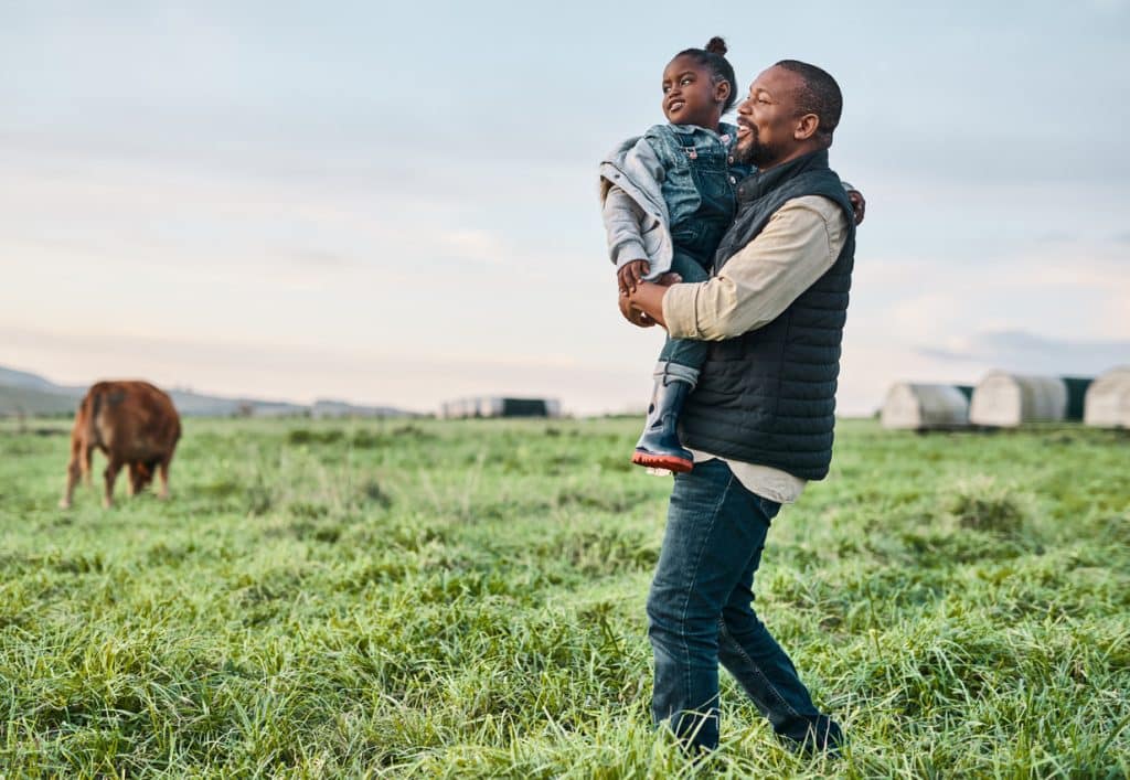 Man walking while carrying young daughter