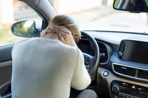 Person suffering from neck pain in car