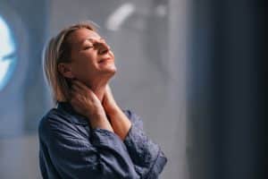Older person smiles while massaging pain-free neck