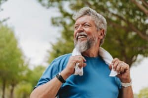 Senior person exercising with towel around neck